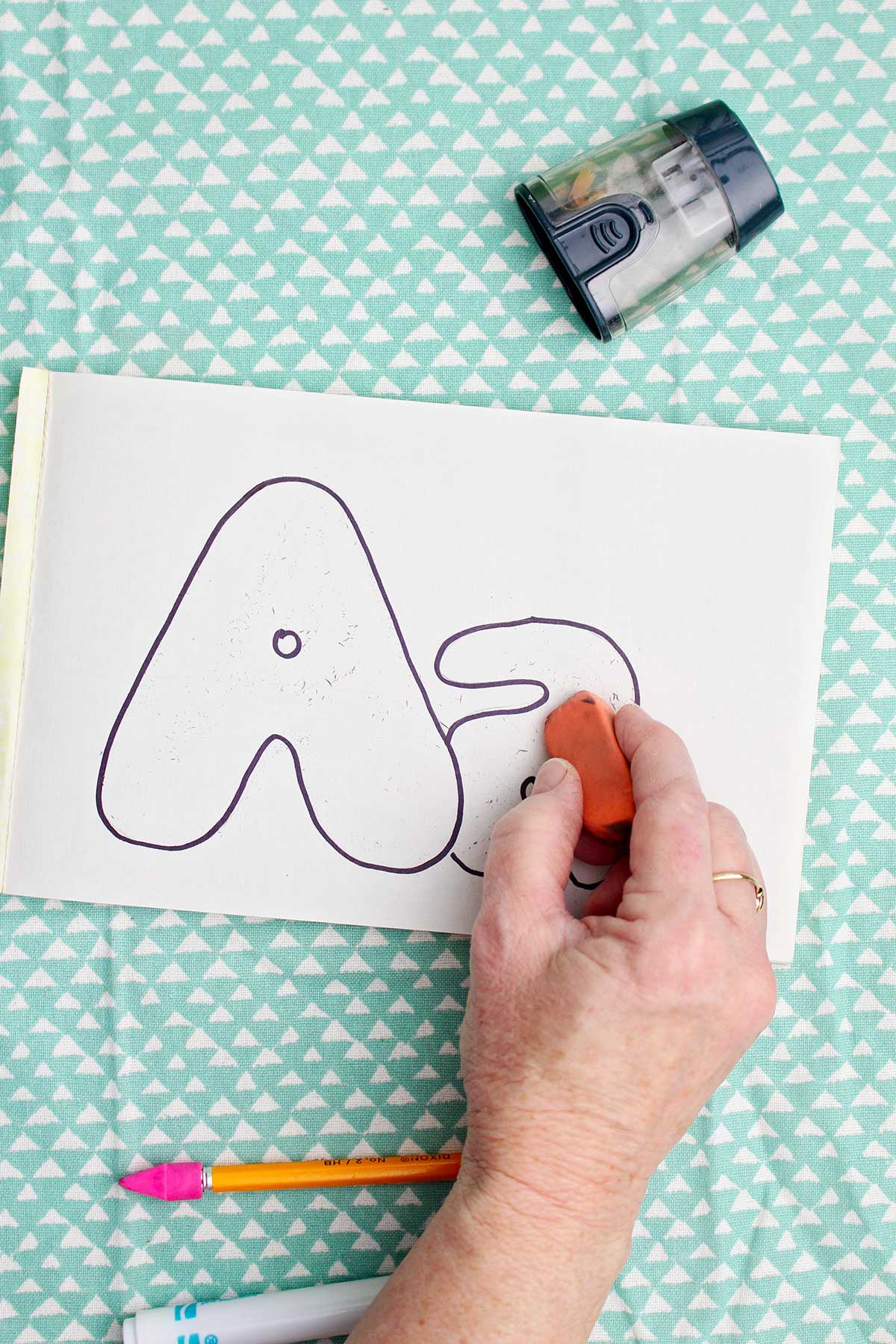 A person erasing the pencil lines.