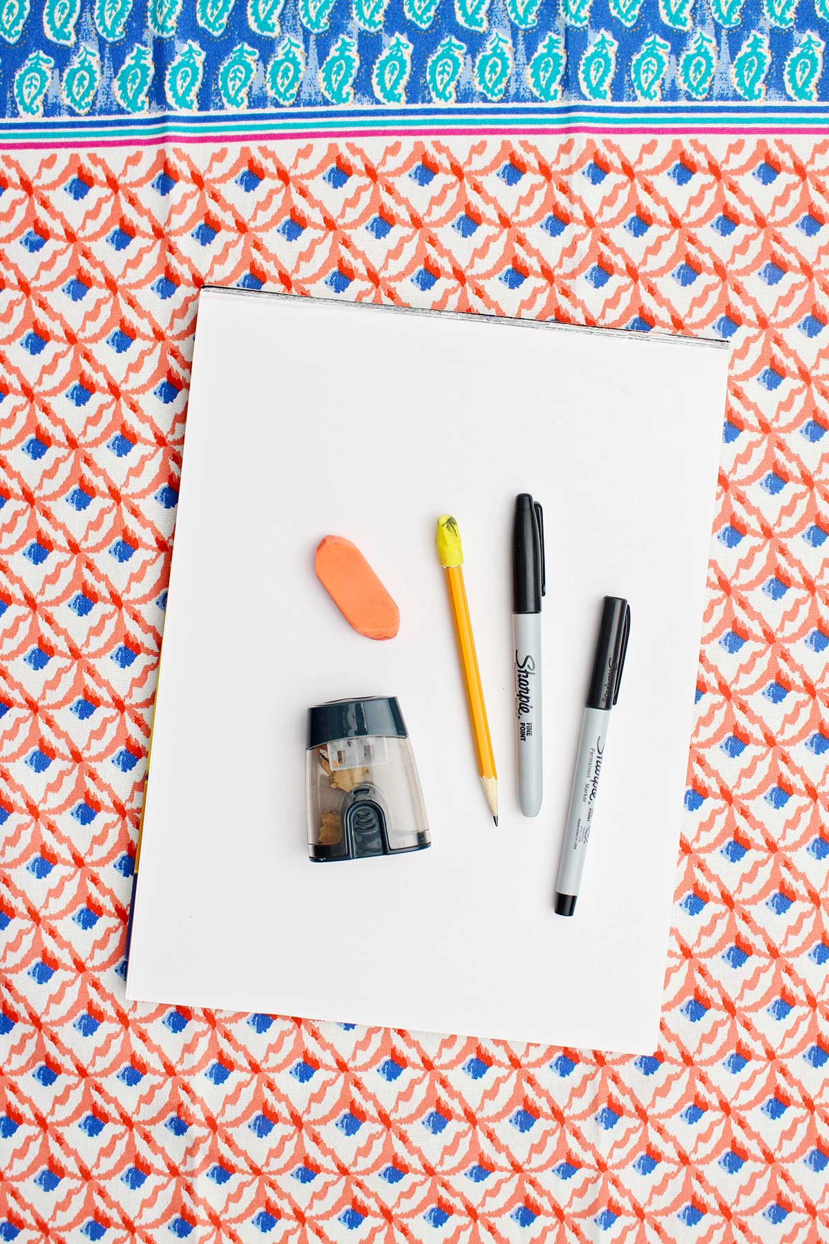 Paper, eraser, pencil, pencil sharpener and sharpies.