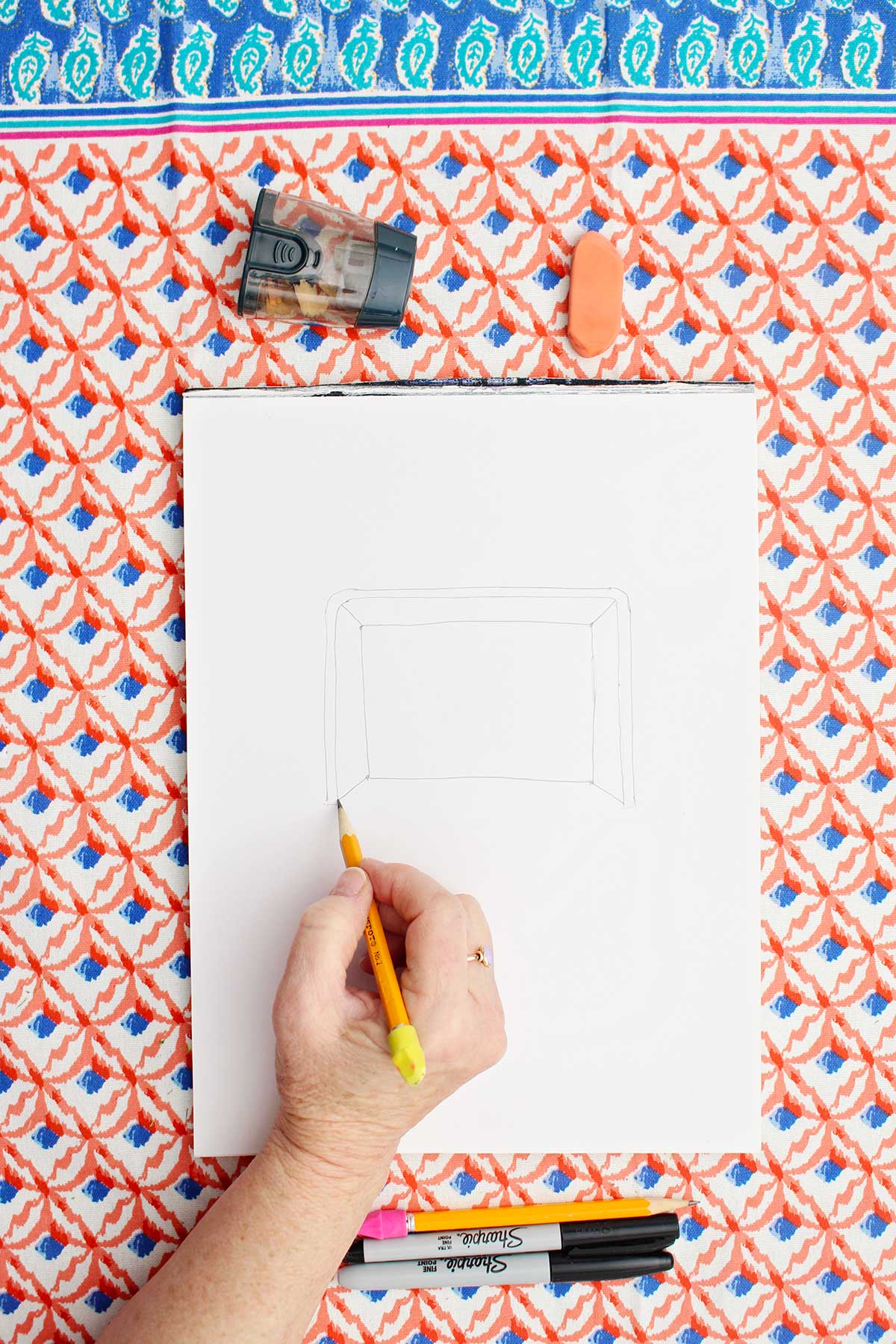 Person sketching a picture of a soccer goal with pencil.