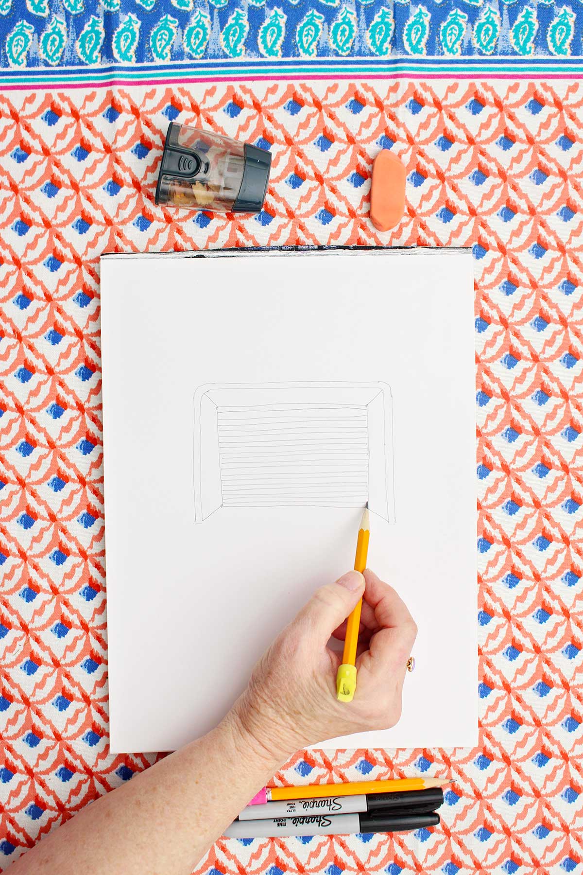 Person sketching a picture of a soccer goal with pencil.