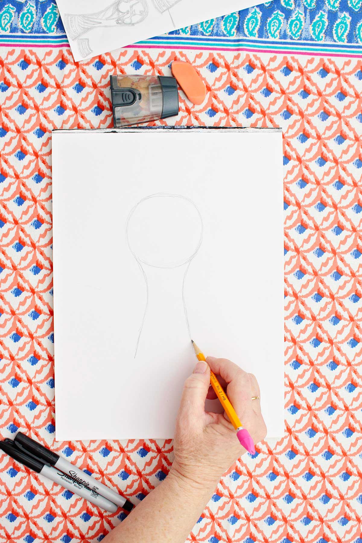 A pencil sketch of a circle with a fluted base on the bottom.