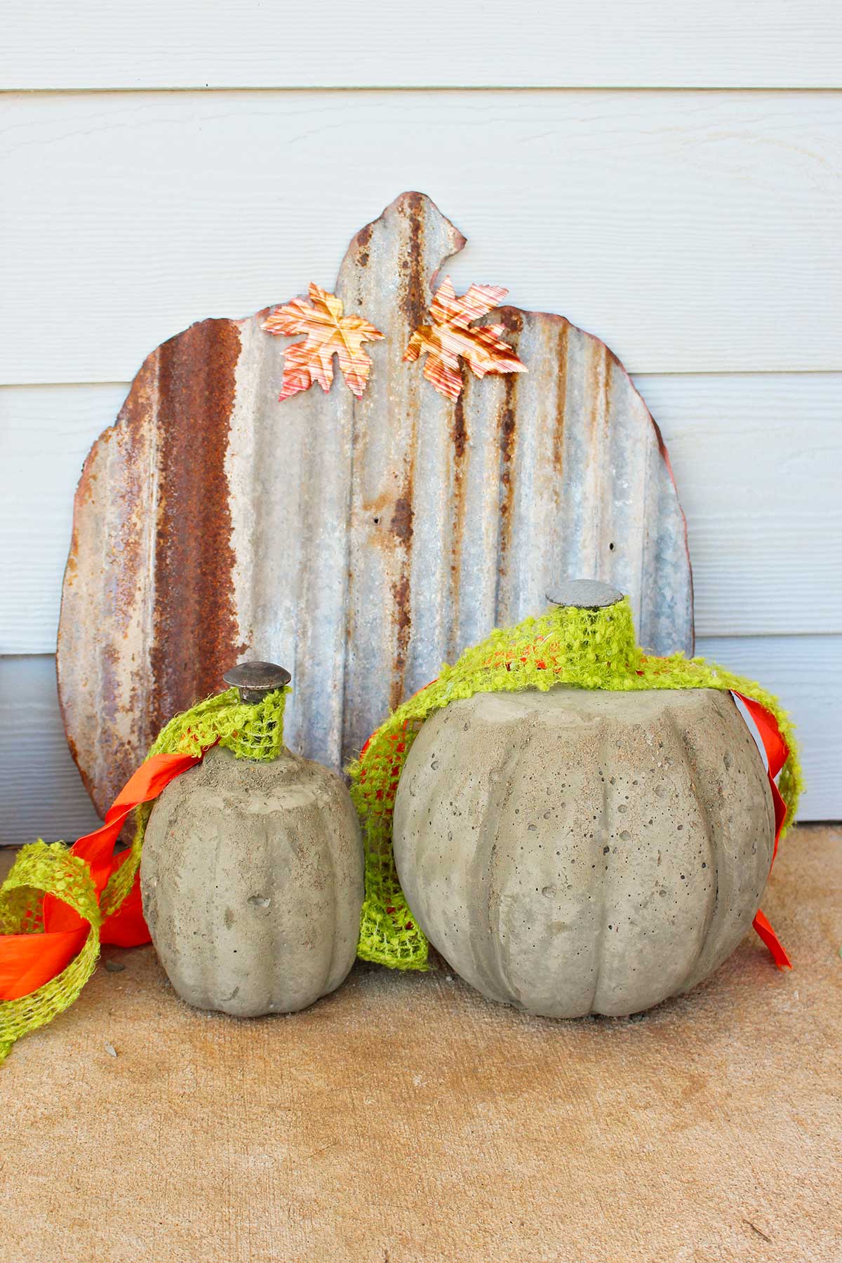 Finished concrete pumpkins sitting on a porch as fall decorations